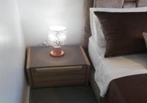 a lamp on a night stand next to a bed at Appart Hôtel Tanger Paname in Tangier