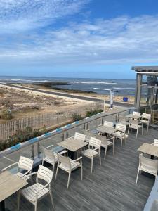 a deck with tables and chairs and the beach at Holikeys - El jadida - 2 Ch - Sidi bouzid 005 in El Jadida