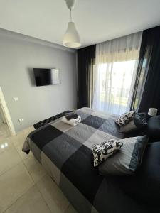 a bedroom with two beds and a large window at Holikeys - El jadida - 2 Ch - Sidi bouzid 005 in El Jadida