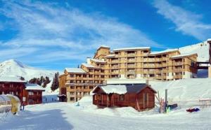 ein großes Gebäude im Schnee vor einem Berg in der Unterkunft Duplex skis aux pieds Belle Plagne in Belle Plagne