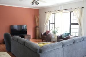 sala de estar con sofá y TV en The Dahlia en Ciudad del Cabo