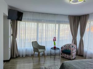a bedroom with a bed and a chair and a window at Casa Boila in Bîrsana