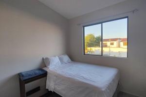 ein kleines Schlafzimmer mit einem Bett und einem Fenster in der Unterkunft Cómoda casa en Residencial San Andrés in San Miguel