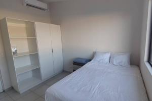 a small bedroom with a white bed and shelves at Cómoda casa en Residencial San Andrés in San Miguel