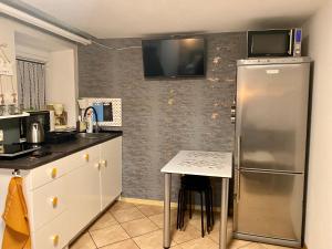 a kitchen with a stainless steel refrigerator and a table at Apartament Majówka in Ustrzyki Dolne