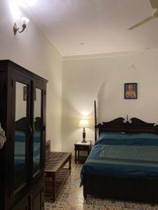 a bedroom with a bed and a table and a lamp at Dera Padlia - A Rural Experience Farm Stay 