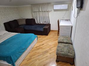 a living room with a bed and a couch at GUEST HAUSE & HOSTEL 15a in Kʼutʼaisi