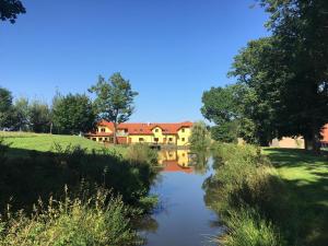 een huis aan de kant van een rivier bij Podveský mlýn in Tlumačov
