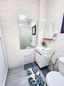 a white bathroom with a sink and a mirror at F3 Appart Les Ambassades - Point E - Dakar in Dakar