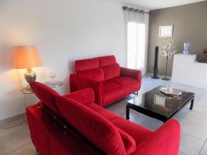 een woonkamer met een rode bank en een tafel bij Les Mathes La Palmyre - SUBLIME MAISON de plain-pied - TOUT CONFORT au calme in Les Mathes