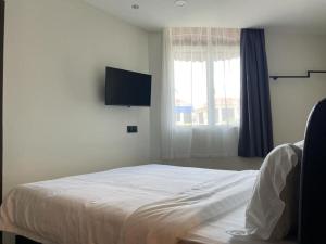 a bedroom with a bed and a flat screen tv at Soho Tabuan Kuching in Kuching +7 photos