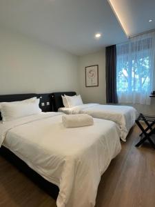 - 2 lits dans une chambre d'hôtel avec des draps blancs dans l'établissement Soho Tabuan Kuching, à Kuching