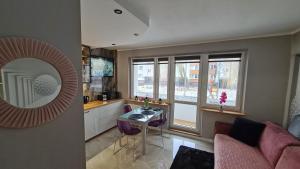 a kitchen and living room with a table and a mirror at Modlin Deluxe Suite in Nowy Dwór Mazowiecki