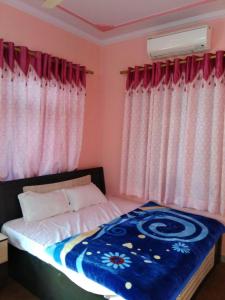 ein Schlafzimmer mit einem Bett mit einer blauen und weißen Decke in der Unterkunft Hotel zamarrud palace in Jaipur