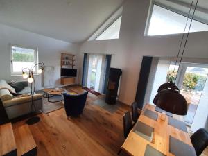 a living room with a dining table and a living room with a couch at Ferienhaus "Achter de Schmeed" in Westfehmarn