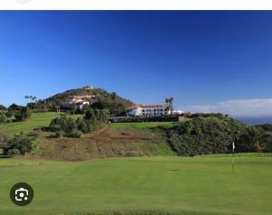 einen Golfplatz mit einem Haus auf einem Hügel in der Unterkunft El sosiego, der Rückzugsort in Santa Brígida