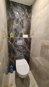 bagno con servizi igienici e parete in marmo nero di Modlin Deluxe Suite a Nowy Dwór Mazowiecki