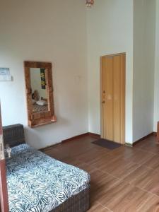 a room with a couch and a mirror and a door at Calmness Villa Syariah in Sekupang
