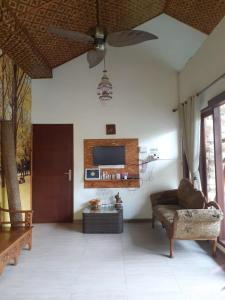 a living room with a couch and a ceiling fan at Calmness Villa Syariah in Sekupang