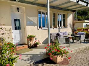 ein Haus mit einer Veranda mit Stühlen und Blumen in der Unterkunft Romantic Lake & Mountain apartment Pure Swissness in Brienz