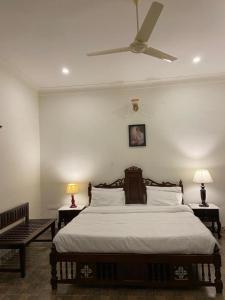 a bedroom with a bed and a ceiling fan at Dera Padlia - A Rural Experience Farm Stay 