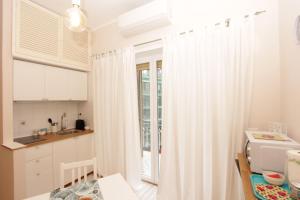 ローマにあるAurelia Flatの小さなキッチン(白いカーテン、窓付)