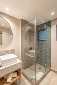 a bathroom with a sink and a shower at Plett Quarter Hotel - Lion Roars Hotels & Lodges in Plettenberg Bay