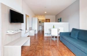 a living room with a blue couch and a table at Hotel New Folías in San Agustin