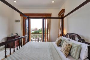 a bedroom with a bed and a balcony at Shree Deogarh Niwas in Udaipur