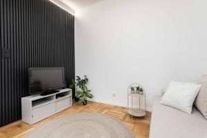 a living room with a tv and a couch at Vanilla Apartment Ochota in Warsaw