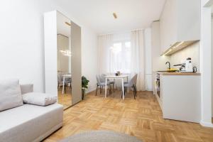 a living room with a kitchen and a table with chairs at Vanilla Apartment Ochota in Warsaw
