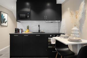 a kitchen with black cabinets and a white counter top at Renovated jan 24 - Queen beds - Behind Bryggen in Bergen +9 photos