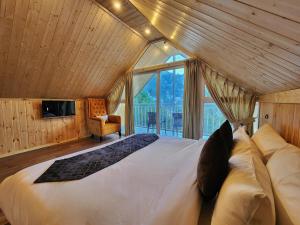 a bedroom with a large bed in a room with a window at Kukoo's Nest Kasauli in Kasauli