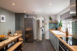 a kitchen with a stainless steel refrigerator and a counter at Bridge End Cottage in Stainforth