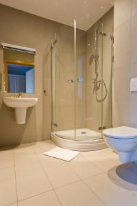 La salle de bains est pourvue d'une douche, de toilettes et d'un lavabo. dans l'établissement Pokoje Gościnne Stara Kopalnia, à Wałbrzych