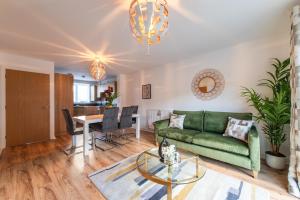 uma sala de estar com um sofá verde e uma mesa em THE RISE - A beautiful 2 bedroom house, only 17mins to Central London!!! em Northfleet