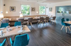 Lahn Hotel في بيدينكوبْفْ: مطعم بطاولات خشبية وكراسي زرقاء