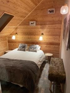 a bedroom with a bed in a wooden cabin at Chez nous piste noire in Briançon