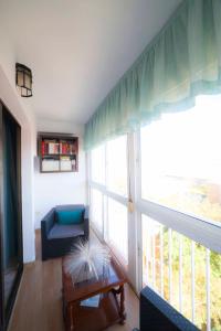 ein Wohnzimmer mit einem Sofa und einem großen Fenster in der Unterkunft SJE - Shiny apartment close to the river in Sevilla