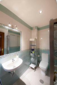 y baño con aseo y lavamanos. en SJE - Shiny apartment close to the river en Sevilla