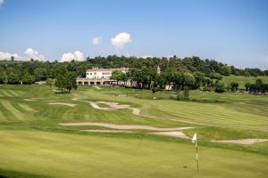 Calvagese della RivieraにあるQC Termegarda Spa & Golf Resortのゴルフコースの景色を望む緑豊かな客室です。