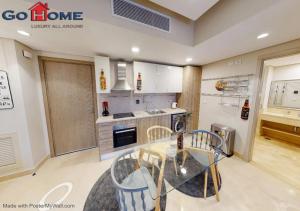 eine Küche mit einem Glastisch und Stühlen in der Unterkunft Stylish 1BR @ Mangroovy-M7-6B in Hurghada