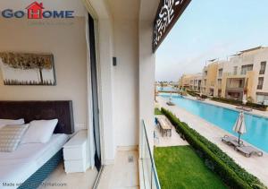 ein Balkon eines Hotels mit einem Bett und einem Swimmingpool in der Unterkunft Stylish 1BR @ Mangroovy-M7-6B in Hurghada