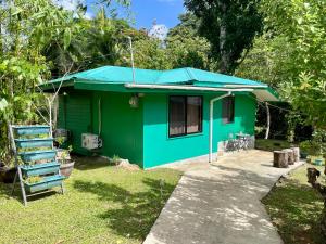 a green house with a blue roof at Ngermid Oasis Cozy 2 BD 1BA Home, Scenic View, Secluded, Beautiful Location in Koror