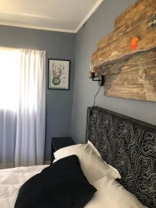 a bedroom with a bed with a wooden headboard at Kieron's Cottage in Lydenburg