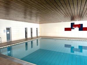 a large swimming pool in a large room at FeWo AllgäuZeit mit Hallenbad & Sauna & kostenlosem WLAN in Missen-Wilhams