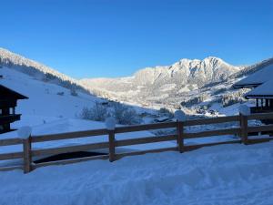 a fence covered in snow with mountains in the background at Apartment Alpbachtraum in Alpbach