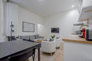 a kitchen and living room with a table and a couch at Central Apt 7px a 50 metros de Retiro-Museo del Prado in Madrid