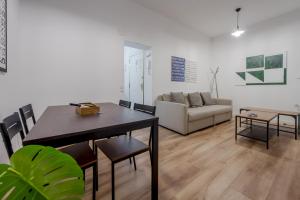 sala de estar con mesa y sofá en C-Cabeza Cool Apt para 7 al lado de Tirso de Molina, en Madrid