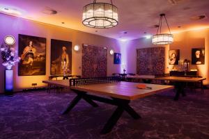 two ping pong tables in a room with paintings at Hotel Berlin, Berlin, a member of Radisson Individuals in Berlin